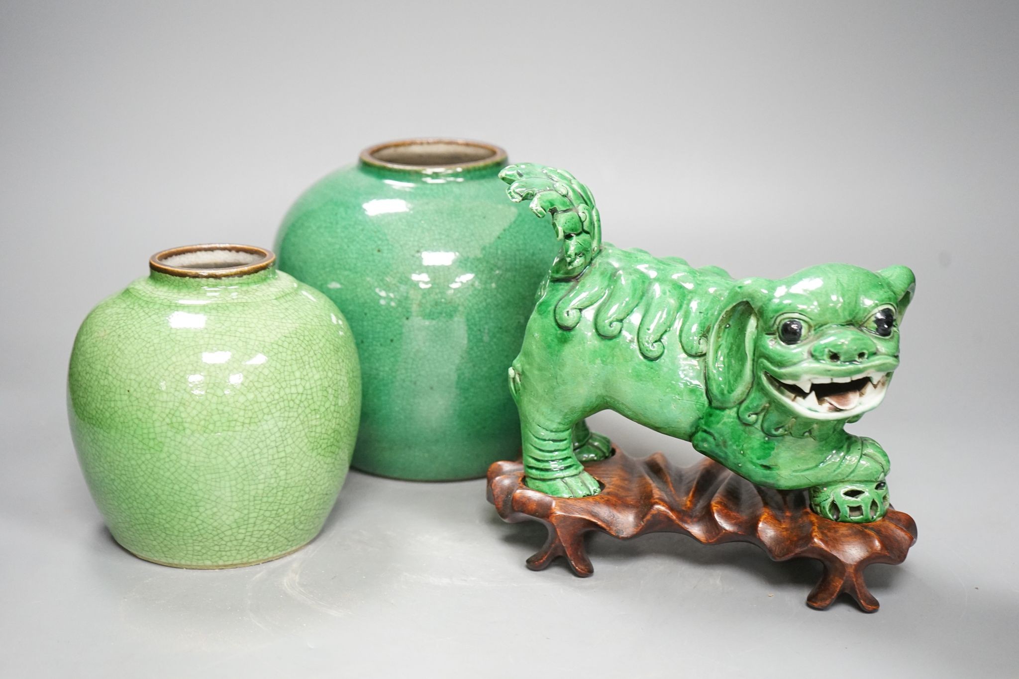 A 19th century Chinese green glazed model of a lion-dog, and two green crackle glaze jars, tallest 16cm